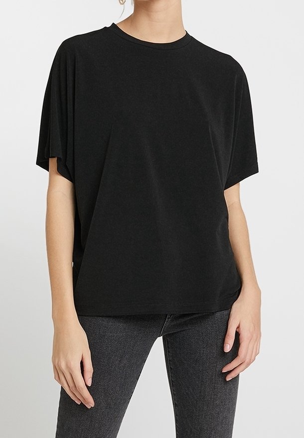 Black oversized short-sleeve t-shirt in soft fabric. Round neckline and relaxed fit, complemented by subtle side slits.