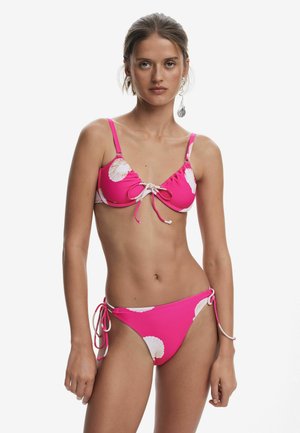 Rosa bikini med vitt snäckmönster; justerbara knytningar upptill och på sidorna; mjukt tyg med en slät textur.