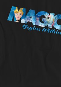 Black T-shirt featuring large, colorful graphic text "MAGIC" with blue accents and the phrase "Begins Within," alongside illustrations of Disney princesses.
