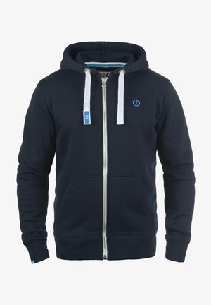 Marineblauwe zip-up hoodie met witte koordjes, voorzakken, geribbelde manchetten en een blauw logo op de borst, gemaakt van zachte stof.