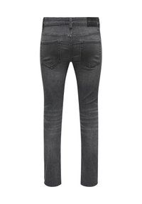 Jeans de mezclilla gris oscuro con un corte ajustado, diseño de cinco bolsillos, textura desvanecida y una etiqueta negra de marca en la cintura.