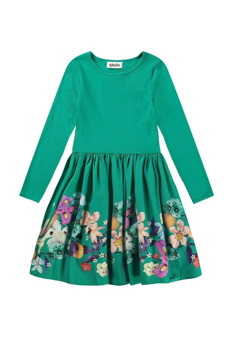 Långärmad grön klänning med en figurnära överdel och en utsvängd kjol, med ett färgglatt blommönster vid fållen. Tyget ser slätt och mjukt ut.