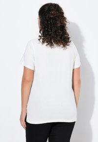 Bílá krátkosrstá tričko s kulatým výstřihem, hladký materiál a volný střih, zobrazené zezadu na jednobarevném pozadí.