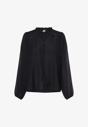 Lös, långärmad svart blus medVolangkrage och en liten knut vid halsringningen mot en vit bakgrund.