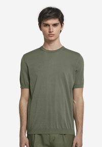 T-shirt med kort ärm och rund halsringning i olivgrön färg, tillverkad av mjukt tyg med en slät yta; har uppvikta ärmar och en något avslappnad passform.