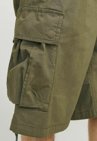 Spodenki cargo w oliwkowym kolorze z teksturowanej tkaniny, z dużą kieszenią boczną, szwami szytymi i regulowanym dołem na sznurek.