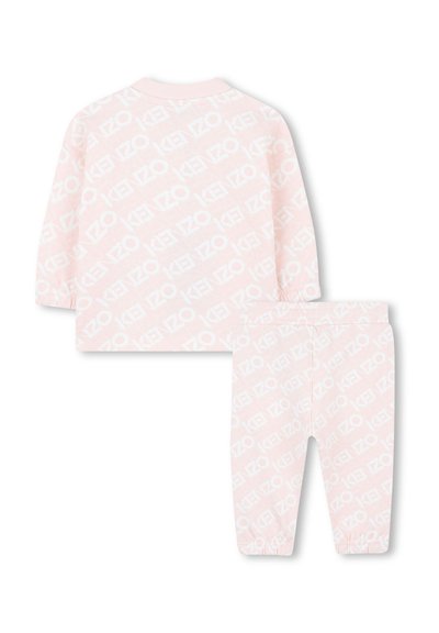 Roze katoenen outfit met een langarmshirt en bijpassende broek, beide versierd met een herhalend wit logopatroon. Inclusief ribboorden aan de mouwen.