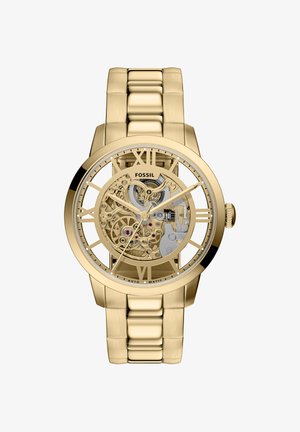 Gold-tone skeleton watch with Roman numerals, stainless steel link bracelet, visible movement details, and polished finish.