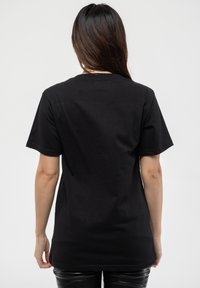 Black cotton t-shirt with short sleeves, a round neckline, and a relaxed fit, featuring a smooth texture and no visible branding or patterns.