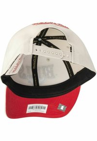 Weißer Baseball-Cap mit rotem Schirm, schwarzem Innenfutter und verstellbarem Snapback-Verschluss. Das „Mitchell & Ness“-Logo ist in rotem Garn auf der Oberseite gestickt.