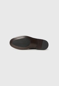 Suela de zapato de cuero marrón con un patrón de textura, talón reforzado y forma redondeada. Presenta acabados lisos y mate.