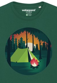 Groen t-shirt met korte mouwen met een ronde afbeelding van een groene tent, een kampvuur en bomen tegen een achtergrond met een zonsonderganggradiënt.