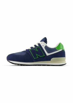 Zapatilla de hombre azul marino con cordones blancos, logo y acento en el talón verdes, suela beige, mostrada de lado sobre fondo blanco.