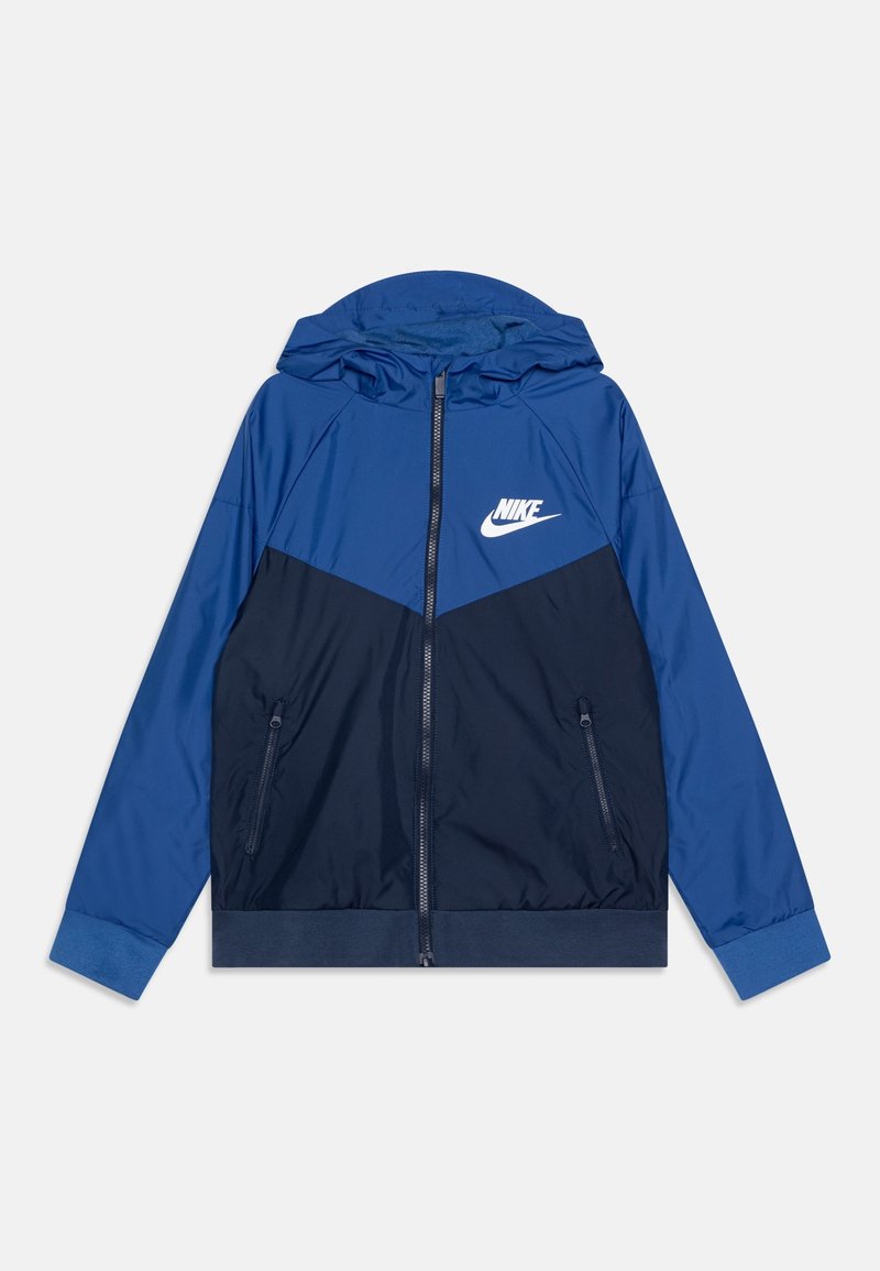 Kurtka Nike z dwukolorowym wzorem w jasnoniebiesko-ciemnoniebieskiej kolorystyce, zapinana na zamek, z kapturem i kieszeniami bocznymi.