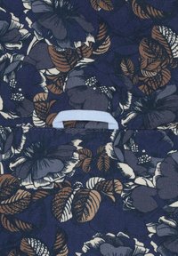 Floral stof in marineblauw met paarse en bruine bloemen en bladeren; heeft in het midden een lichtblauwe hengsel.