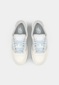 Baskets Vans en blanc doux et bleu clair. Caractéristiques : tige en daim texturé, bout perforé, lacets plats, et semelles intérieures rembourrées. Design classique.