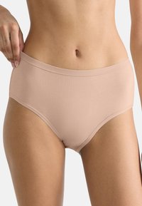 Beige naadloze sliponderbroek met een hoge taille, gemaakt van gladde, rekbare stof. Kenmerkt zich door een nette, afgewerkte tailleband en beenopeningen.