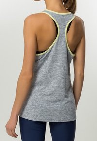 Szary top na ramiączkach z tyłem w stylu wyścigowym, z kontrastowymi jasn Yellow trim i teksturowanym materiałem. Czarny stanik sportowy widoczny pod spodem.