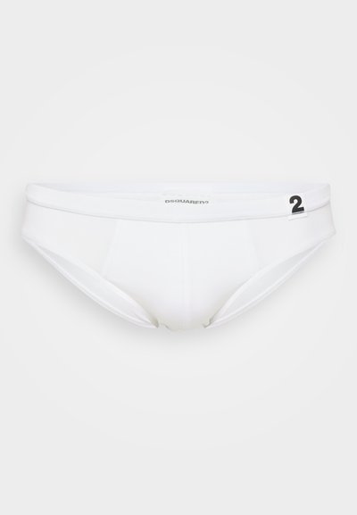 Weiße Baumwollunterhose mit tiefem Bund, ausgestattet mit einem markanten Taillenbund und minimalen Nähten. Enthält ein schwarzes Logo und eine Nummernangabe.