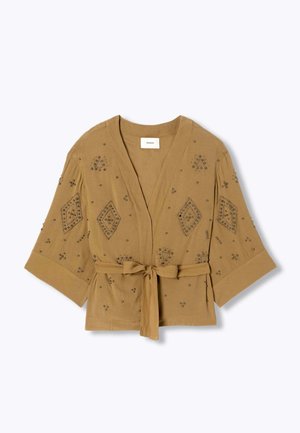 Blouse style kimono marron clair avec larges manches, ceinture à nouer et ornements à clous géométriques sur le devant et les manches.