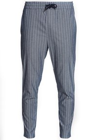 Niebieskie spodnie w paski z elastycznym pasem i sznurkiem. Posiadają zwężane nogawki i gładką fakturę tkaniny.