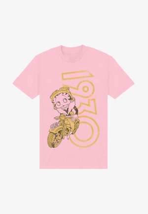 Růžové tričko s karikaturou postavy na žlutém motocyklu, s nápisem "1930" vytištěným tučným zlatým písmem vzadu.