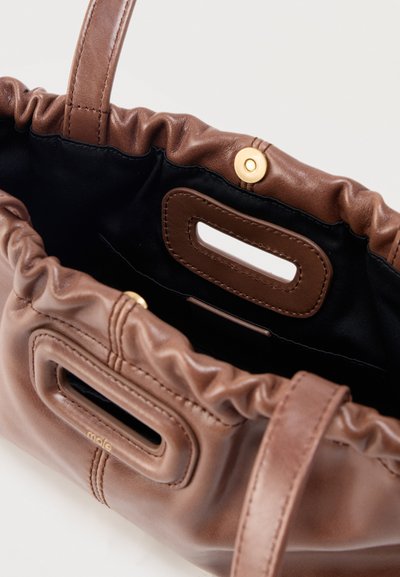 Sac à main en cuir marron avec partie supérieure froncée, poignées ovales renforcées, doublure intérieure noire et fermeture à pression magnétique dorée.