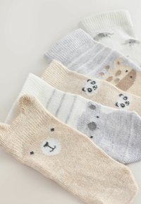 Fünf Paar Socken mit Tiermotiven. Die Farben umfassen Beige, Weiß und Grau. Die Materialien sind weich mit geripptem Textur; einige haben Muster.