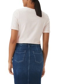 Striped light pink short-sleeve top worn with a blue denim pencil skirt featuring back pockets and a fitted design.