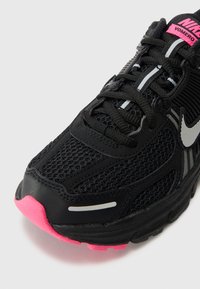 Nike Vomero tenisice za trčanje imaju gornji dio od crne mreže s ružičastim detaljima, sivoj obrubi i teksturiranim potplatom s ružičastim tabanom.
