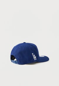 Boné de basebol azul, feito de algodão, com um formato estruturado, logótipo "LA" bordado em branco e fecho snapback na parte de trás.
