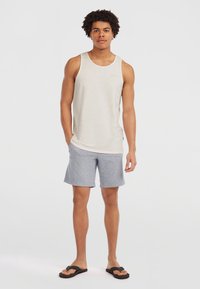 Lys grå tanktop med en subtil tekstur, parret med grå shorts og sorte flip-flops. Enkel design, afslappet pasform, uden synlige mønstre.