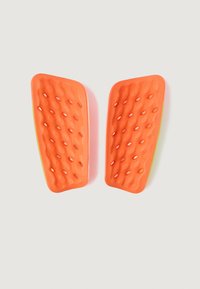 Almohadillas de textura naranja con perforaciones, que presentan un diseño curvado. Los bordes son suaves, y la parte inferior parece tener un color contrastante.