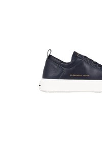 Sneaker in pelle blu navy con superficie texturizzata, suola in gomma bianca e branding dorato. Presenta occhielli in metallo e un pratico tirante sul tallone.