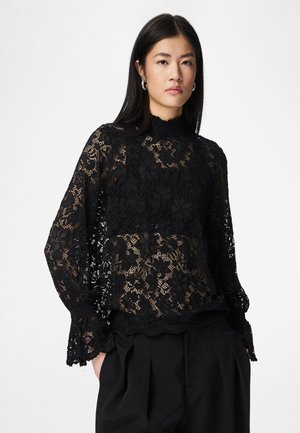 Μπλούζα από μαύρη δαντέλα με ανθισμένα μοτίβα, ψηλό λαιμό και μακριά μανίκια. Διαθέτει σκάλιστο τελείωμα και περίτεχνα σχέδια σε όλη την επιφάνεια.