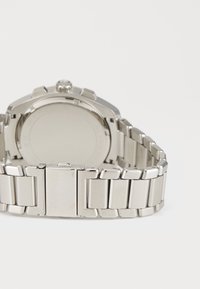 Orologio da polso in metallo argentato con bracciale a maglia spazzolata e lucidata, cassa rotonda e corona. Il retro è liscio e privo di segni.