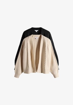 Kaks palmikutega kardigani, üks beež ees ja üks must taga, valgel taustal.