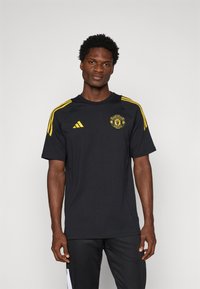 adidas Performance MANCHESTER UNITED 25/26 EUROPEAN COTTON TEE - Article de supporter d'équipe de club - black/tribe yellow