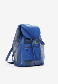 Blaues Mesh-Rucksack mit Lederakzenten, ausgestattet mit einem Deckel, einer vorderen Reißverschluss-Tasche und Logo-Detail. Verstellbare Riemen und strukturierte Oberfläche.