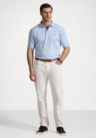 Cămașă polo albastră deschis cu guler, pantaloni bej și curea din piele maro. Adidași negri și un ceas completează ținuta.