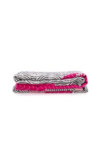 Pila di coperte in pile con un motivo a zebra in bianco e nero e un lato inferiore rosa, texture morbida e colori a contrasto.