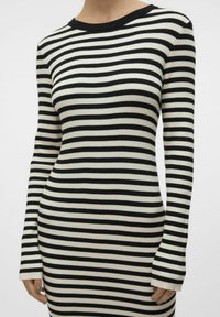 Robe à manches longues rayée noire et crème avec texture côtelée et encolure arrondie ; silhouette ajustée avec petits poignets.