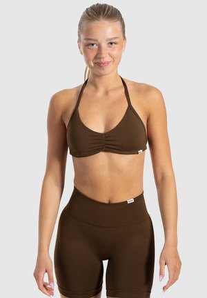 Bruine cropped haltertop met geplooide voorkant, gecombineerd met hoge bruine shorts met een geribbeld tailleband en een gladde textuur.