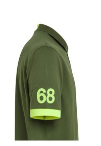 Polo verde con colletto, maniche corte. Presenta rifiniture di un vivace verde lime e il numero "68" ricamato sulla manica sinistra.