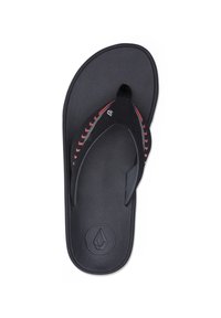 Sandale en caoutchouc noire avec une semelle texturée, présentant un motif contrasté rouge et gris sur la bride et un logo circulaire sur le semelle intérieure.