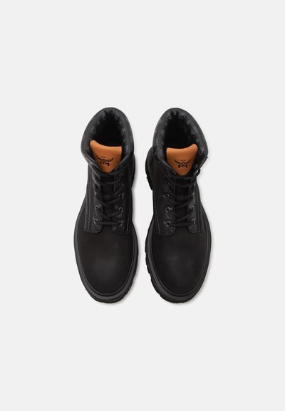 Paire de bottines noires en cuir à lacets avec col matelassé et languettes marron marquées, vues de dessus sur fond blanc.