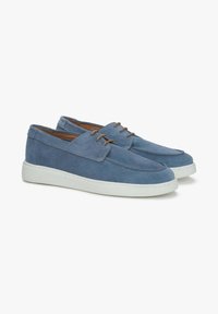 Blauwe suède schoenen met een ronde neus, witte rubberen zool en gestikte accenten. Voorzien van twee bruine veters aan de voorkant.