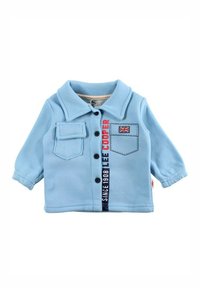 Chemise bleu clair pour tout-petit avec un col à revers, une fermeture à boutons sur le devant, une poche poitrine, un écusson logo, et un détail de texte contrastant.