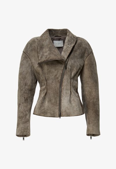 Barna velúr dzseki rövid fazonban, aszimmetrikus elülső cipzárral és túlméretezett gallérral. Szabott varrásokkal és cipzáras mandzsettákkal rendelkezik.