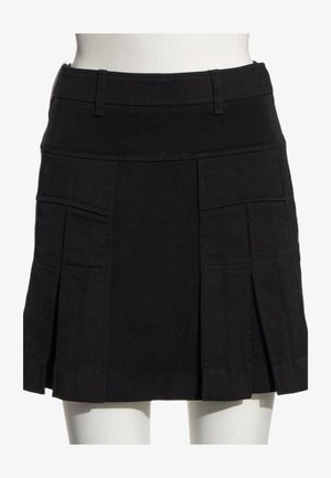 Mini-jupe noire plissée avec poches à rabat devant et passants de ceinture, cintrée à la taille sur un mannequin blanc.